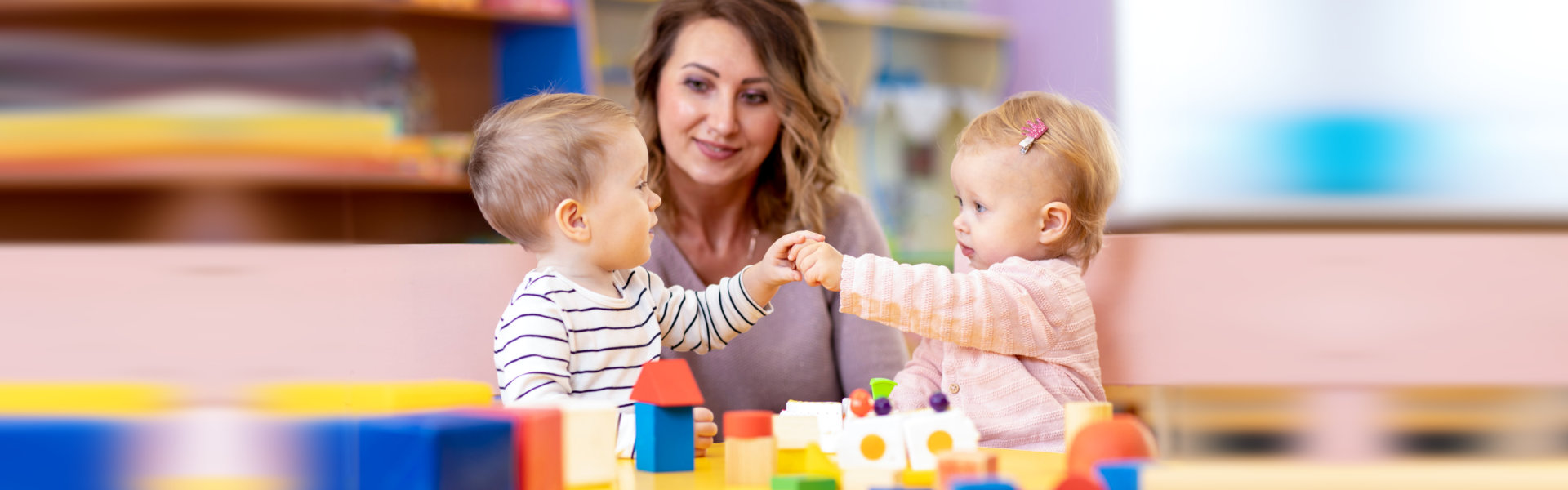 Little caucasian babies playing with Montessori toy